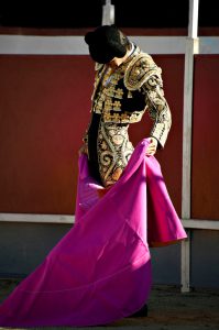 Bullfighter in full costume over a white and red background